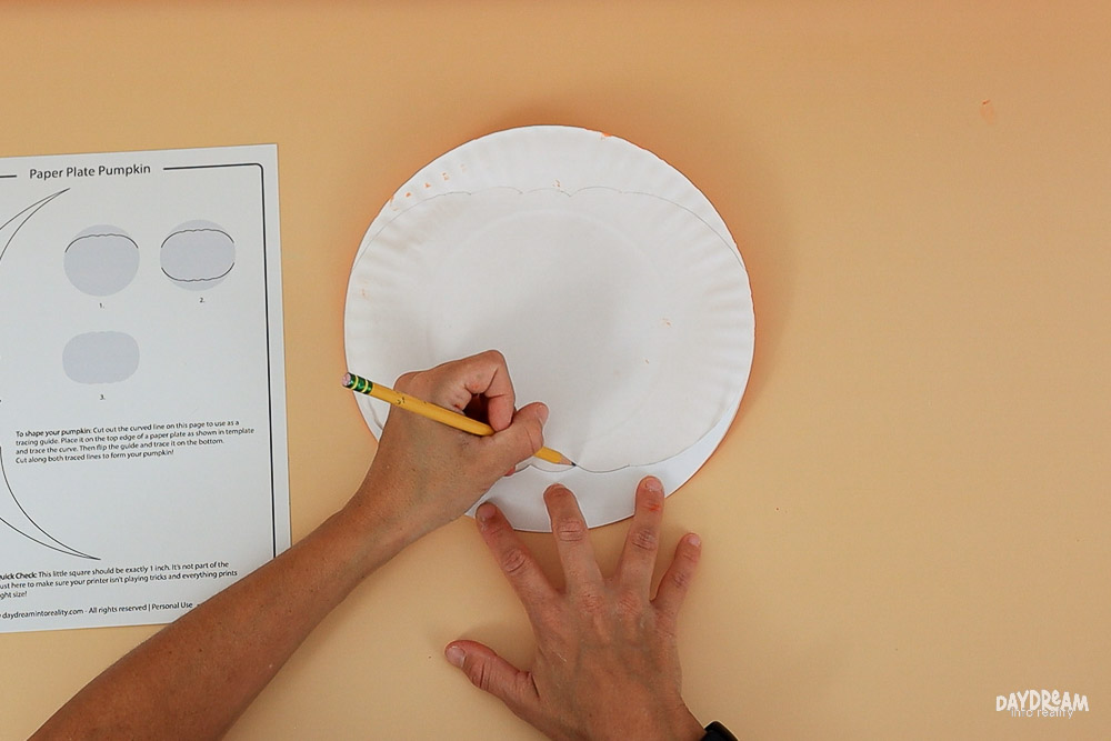 tracing pumpkin shape on back of paper plate
