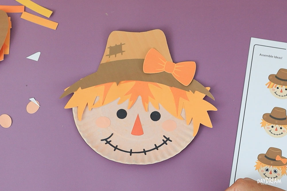 paper plate scarecrow with bow and jagged hair