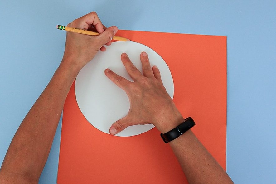 tracing the pie circle template onto orange cardstock