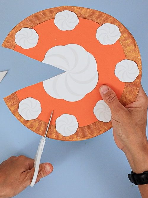 cutting paper plate pumpkin pie craft into slices