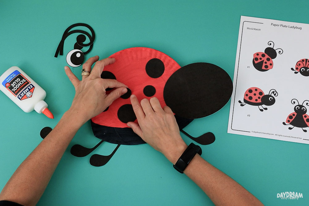 Glue black spots to ladybug.