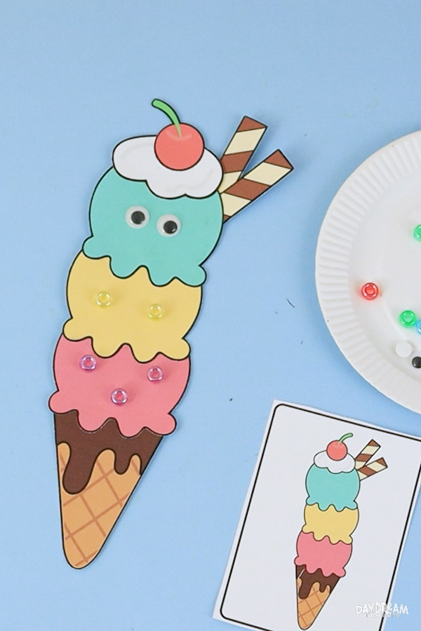 Easy ice cream craft for kids decorated with beads and googly eyes featuring a printable triple scoop ice cream cone summer craft template.