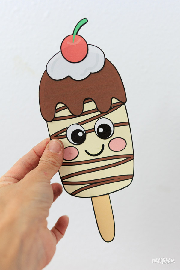 Cute chocolate popsicle craft for kids with whipped cream and cherry on top.