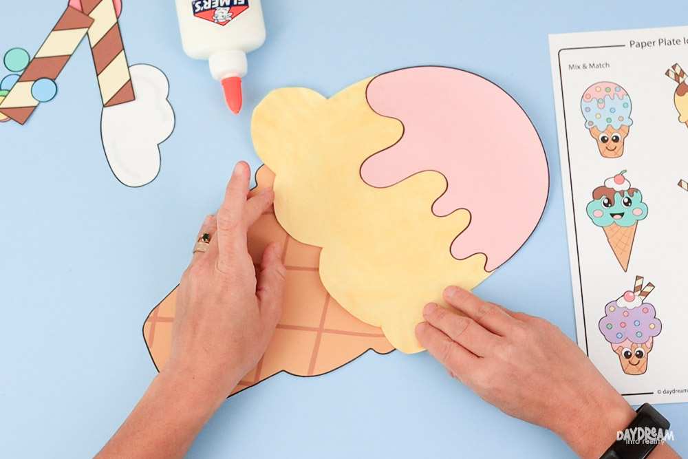 Glue paper plate scoop to cone.